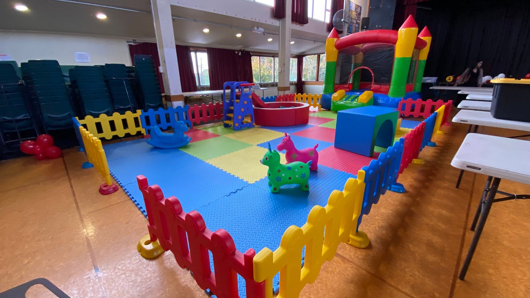 Colourful indoor soft play and bouncy castle setup