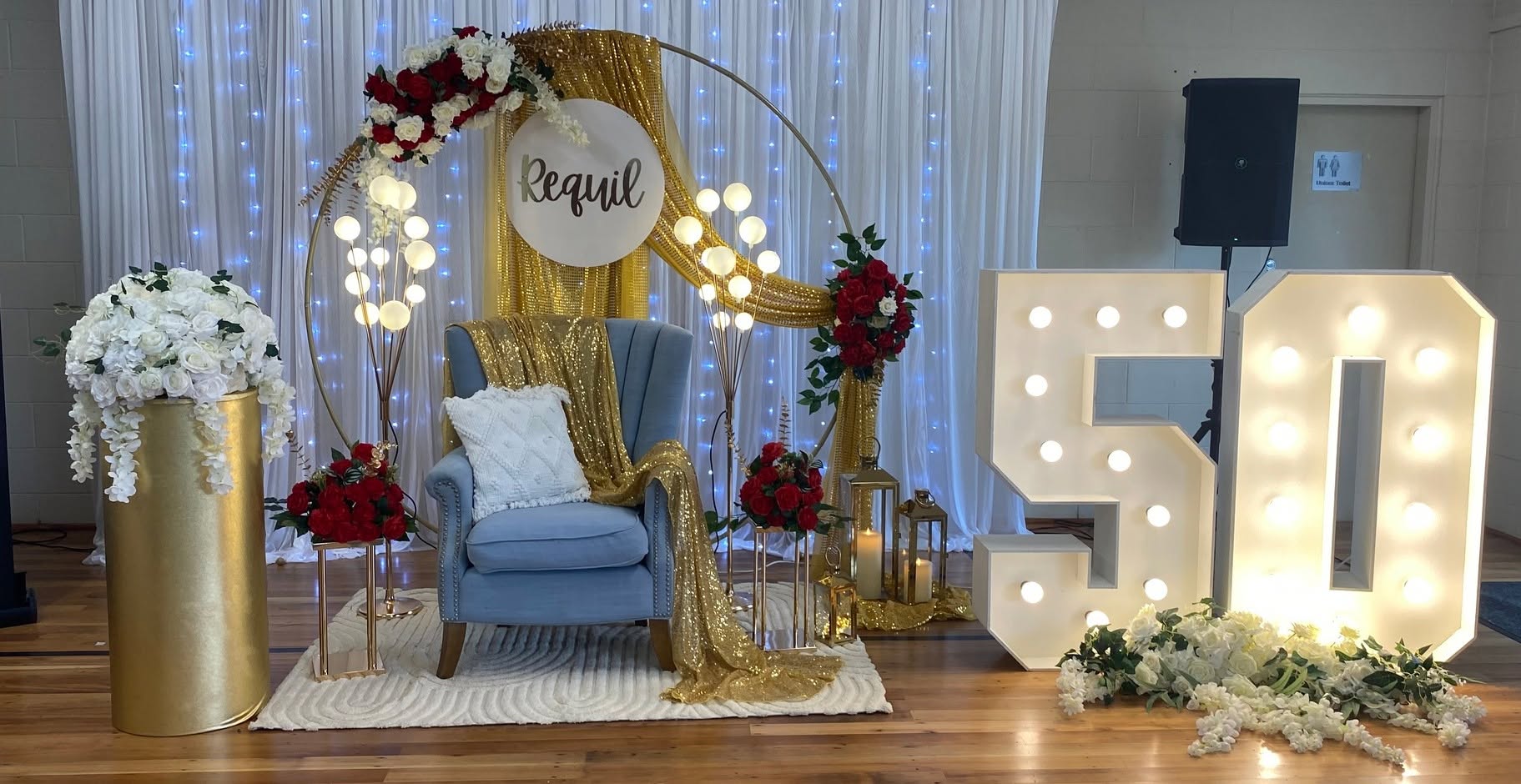 Gold and red 50th birthday backdrop with light-up numbers