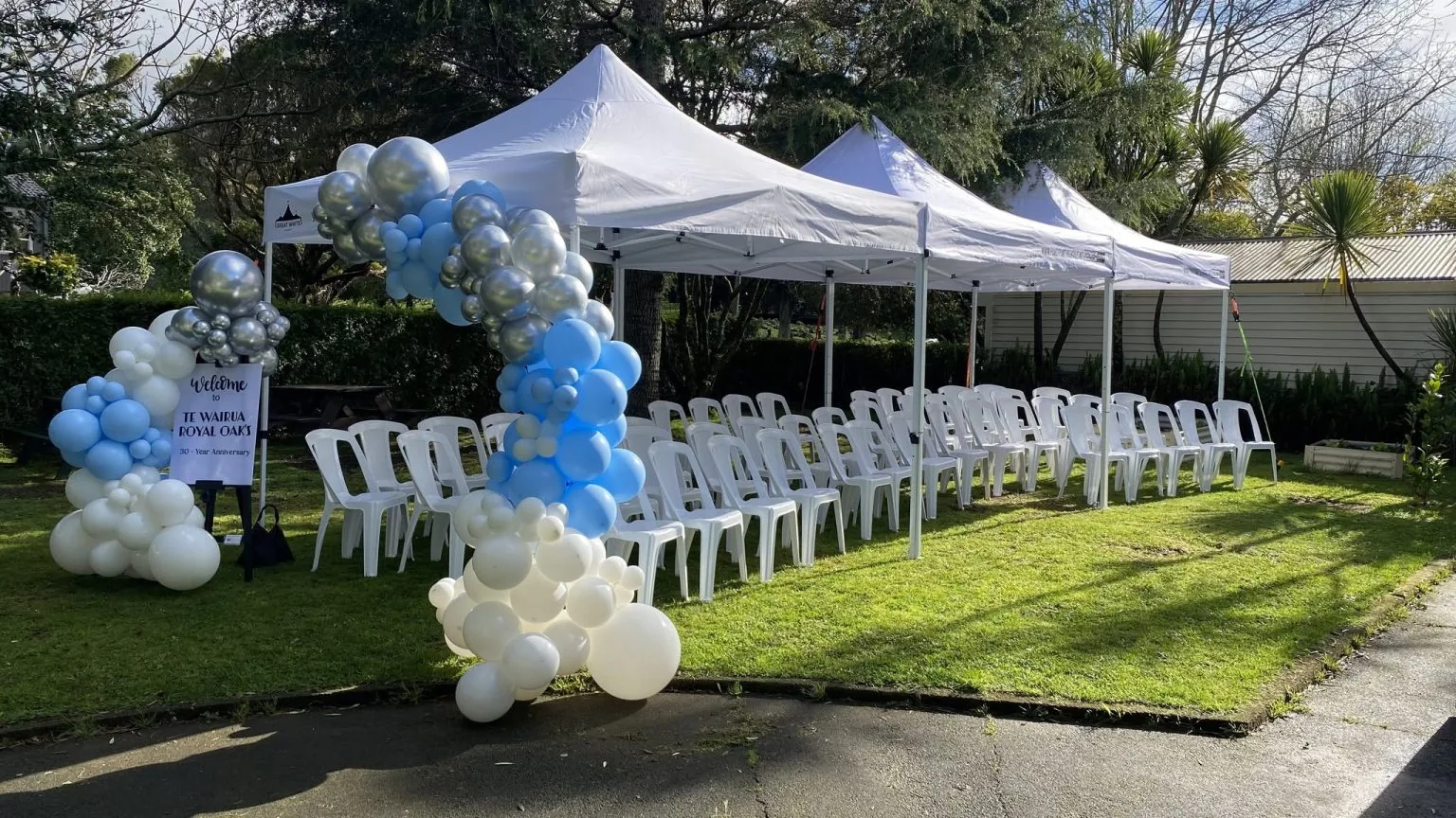 White gazebos and a blue balloon arch at an Auckland event
